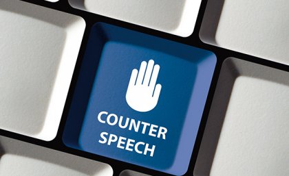 Image: Adobe Picture of the palm of a hand in the stop pose on a Facebook-blue coloured key on a computer keyboard